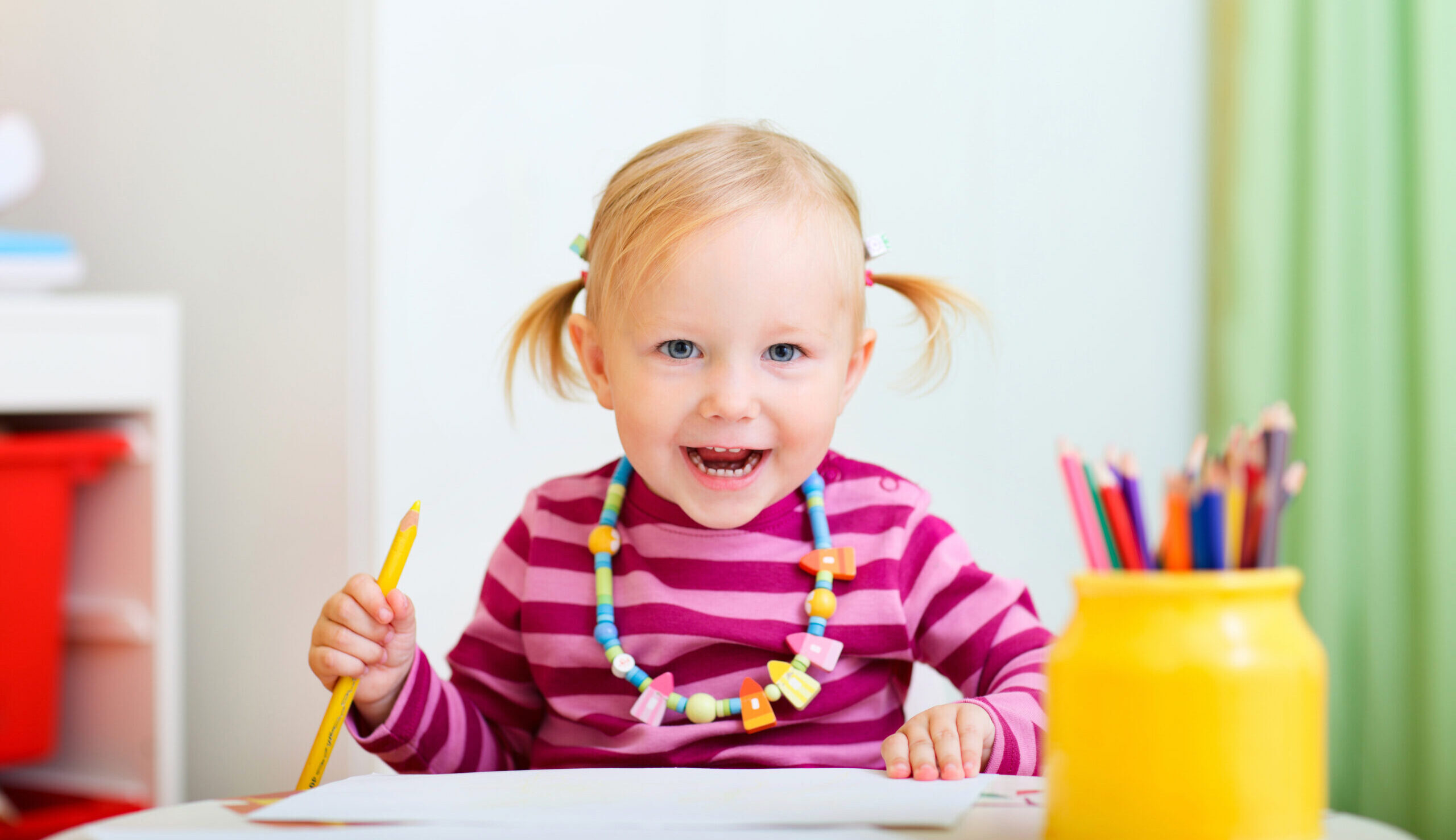 A little girl enjoys drawing with a big smile Sisäportaikko Novum-moduuleissa